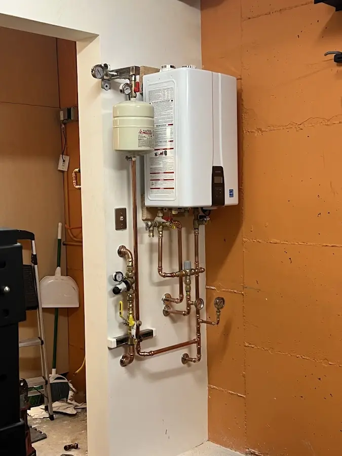 Plumbing technician inspecting water heater connections in Auberry
